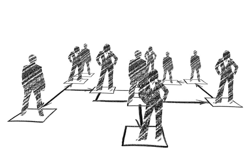 A hand-drawn organizational chart shows figures in suits on boxes connected by arrows, illustrating a hierarchical structure.