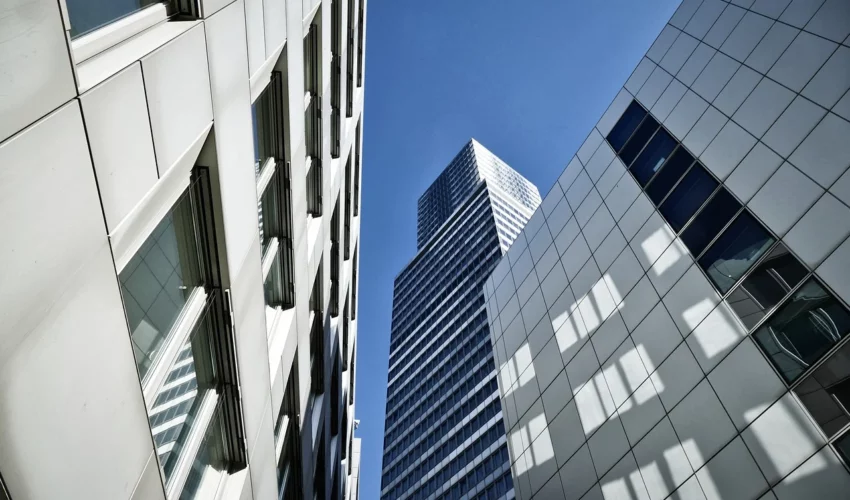 Low angle of modern office buildings against a blue sky.