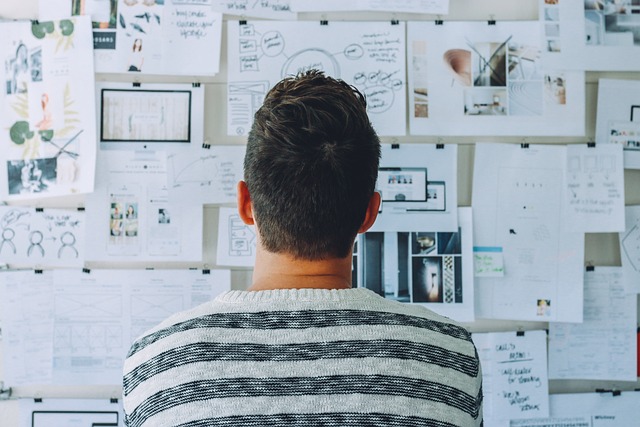 Person views a wall of ideas and notes.